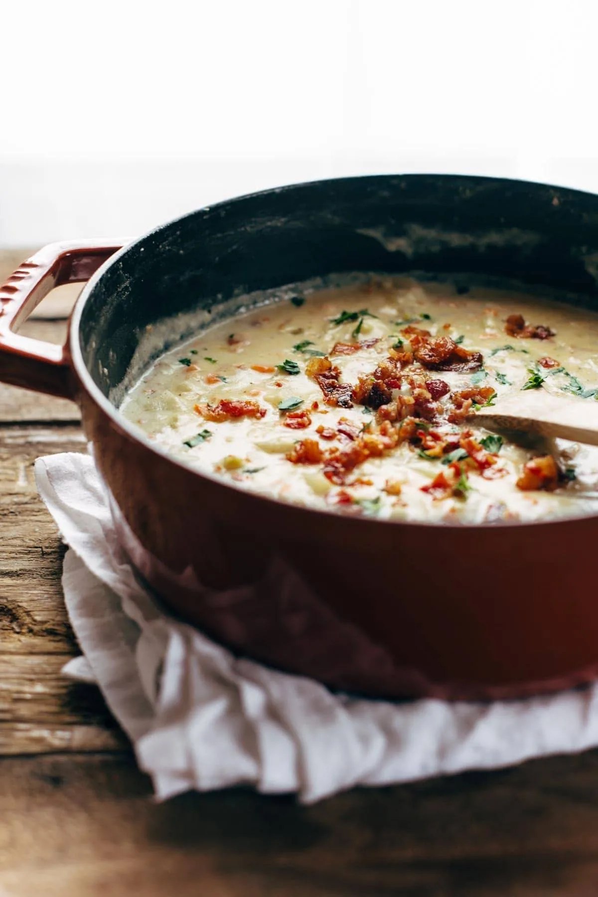 Creamy potato soup topped with bacon in a Dutch oven