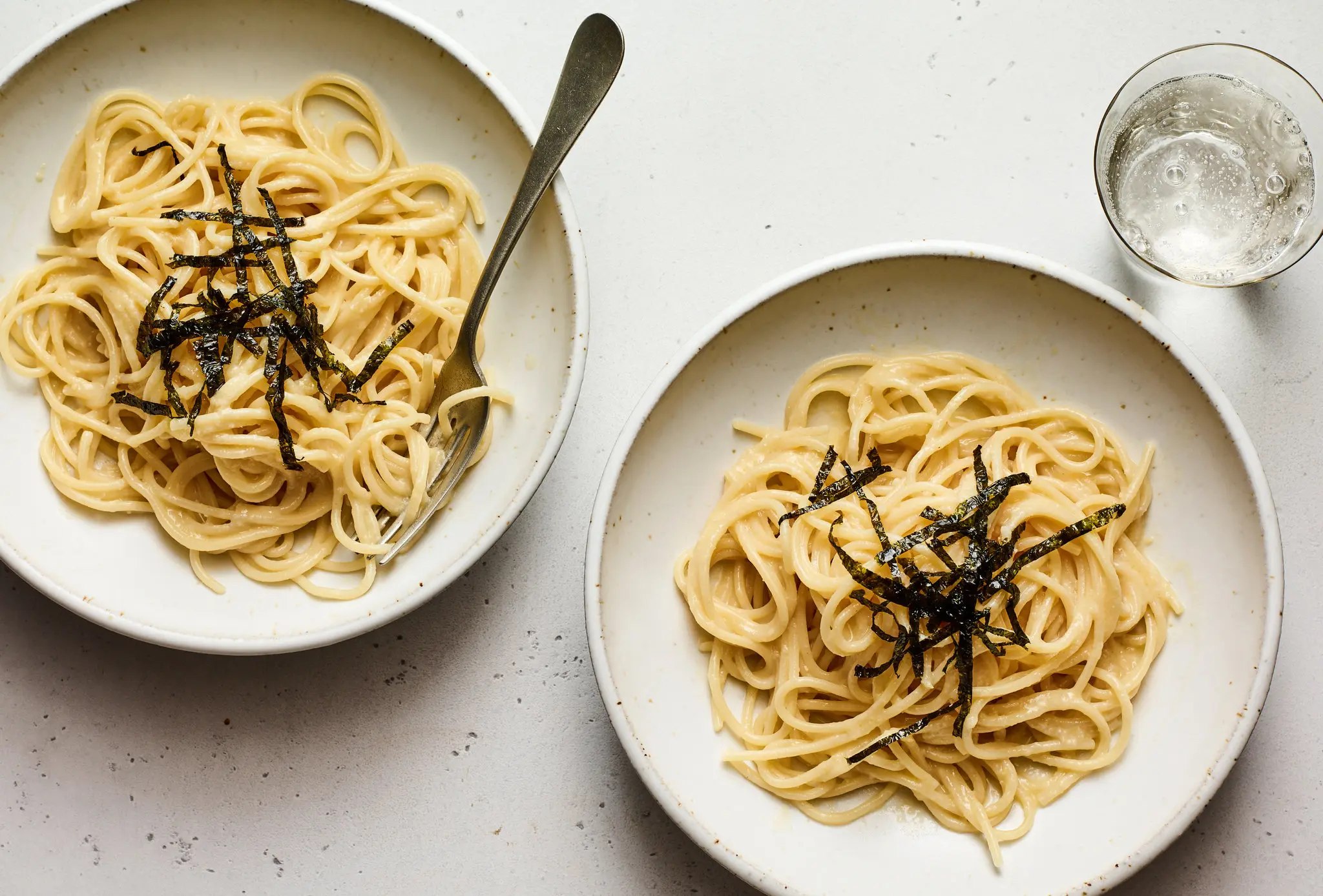 Creamy miso pasta topped with shredded nori in shallow bowls