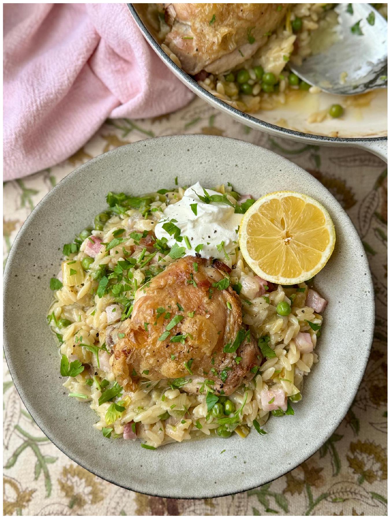 Golden chicken thighs over creamy leek orzo with peas and pancetta