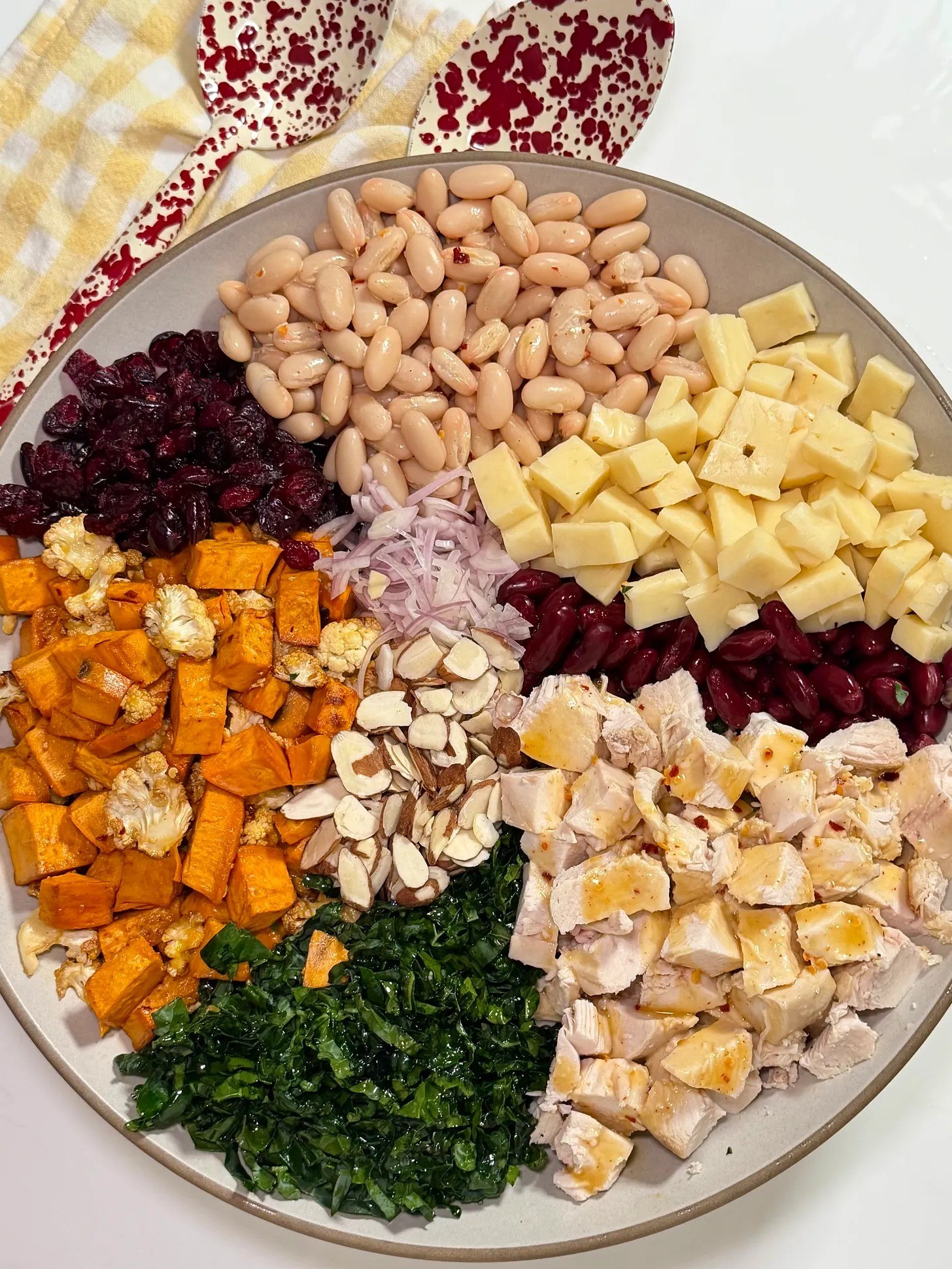 Honey Dijon dense bean salad with chicken, roasted vegetables, beans, cheese, kale, cranberries, and almonds