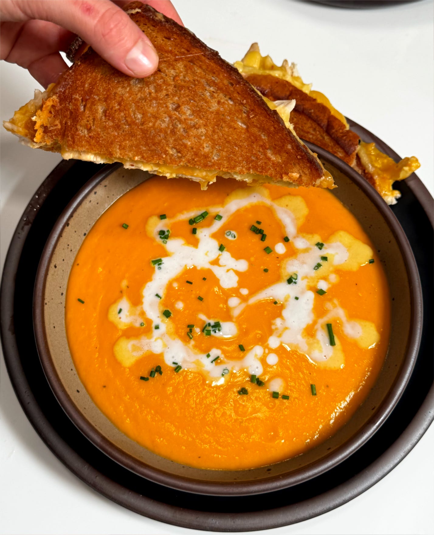 Honeynut squash soup served with a chicken grilled cheese