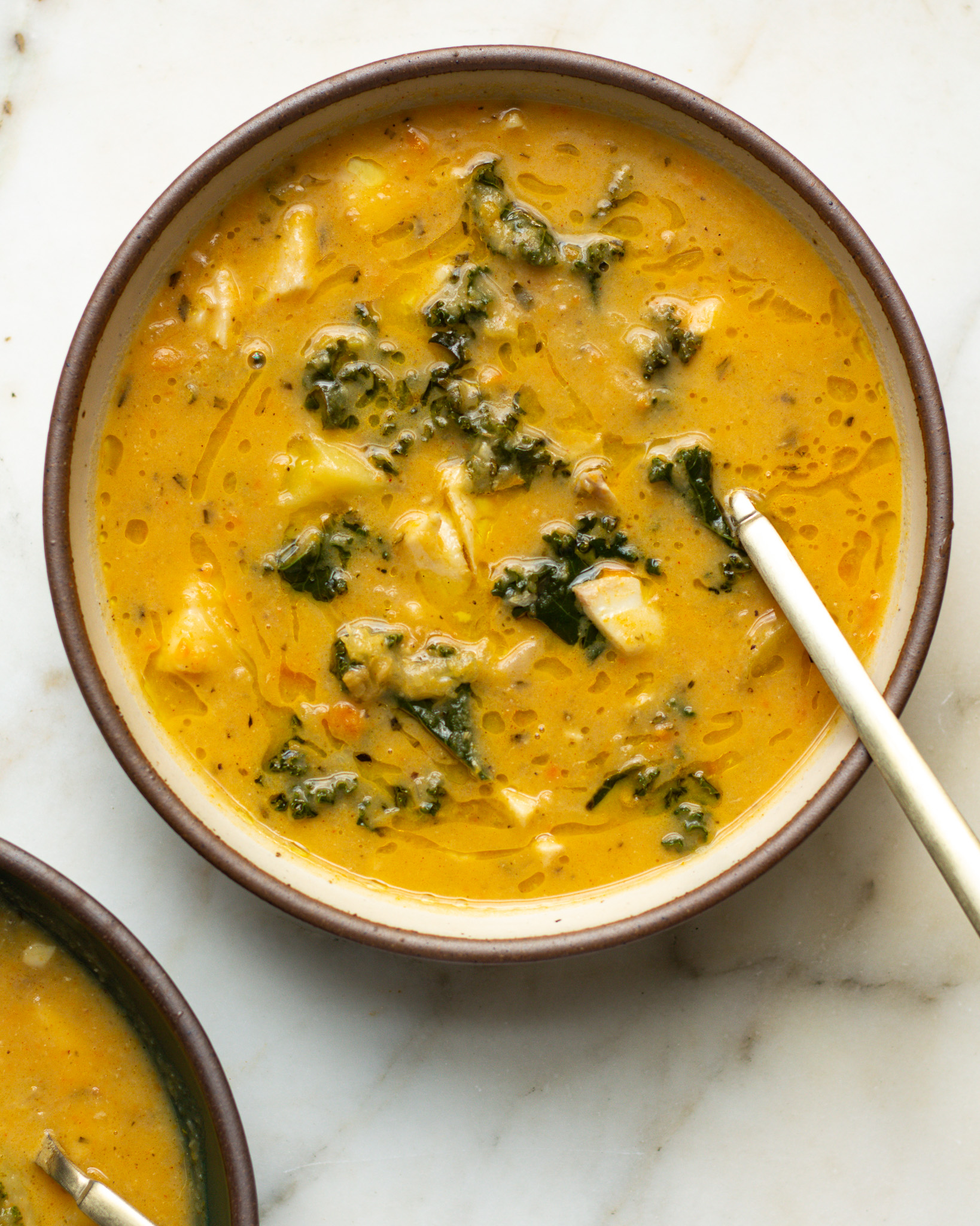Creamy fish chowder with kale, carrots, and potatoes