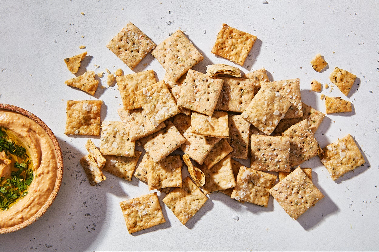 Thin sourdough crackers stacked on a plate