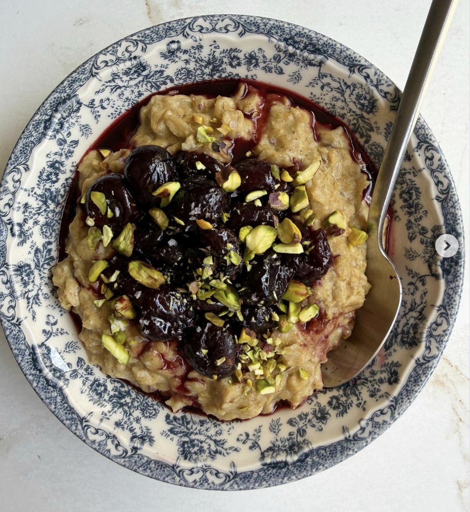 Sticky toffee custard oats topped with cherry compote and pistachios