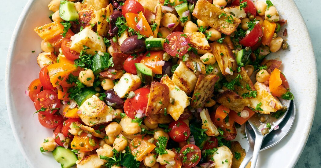 Taverna salad with halloumi, chickpeas, tomatoes, cucumber, olives, and crispy pita