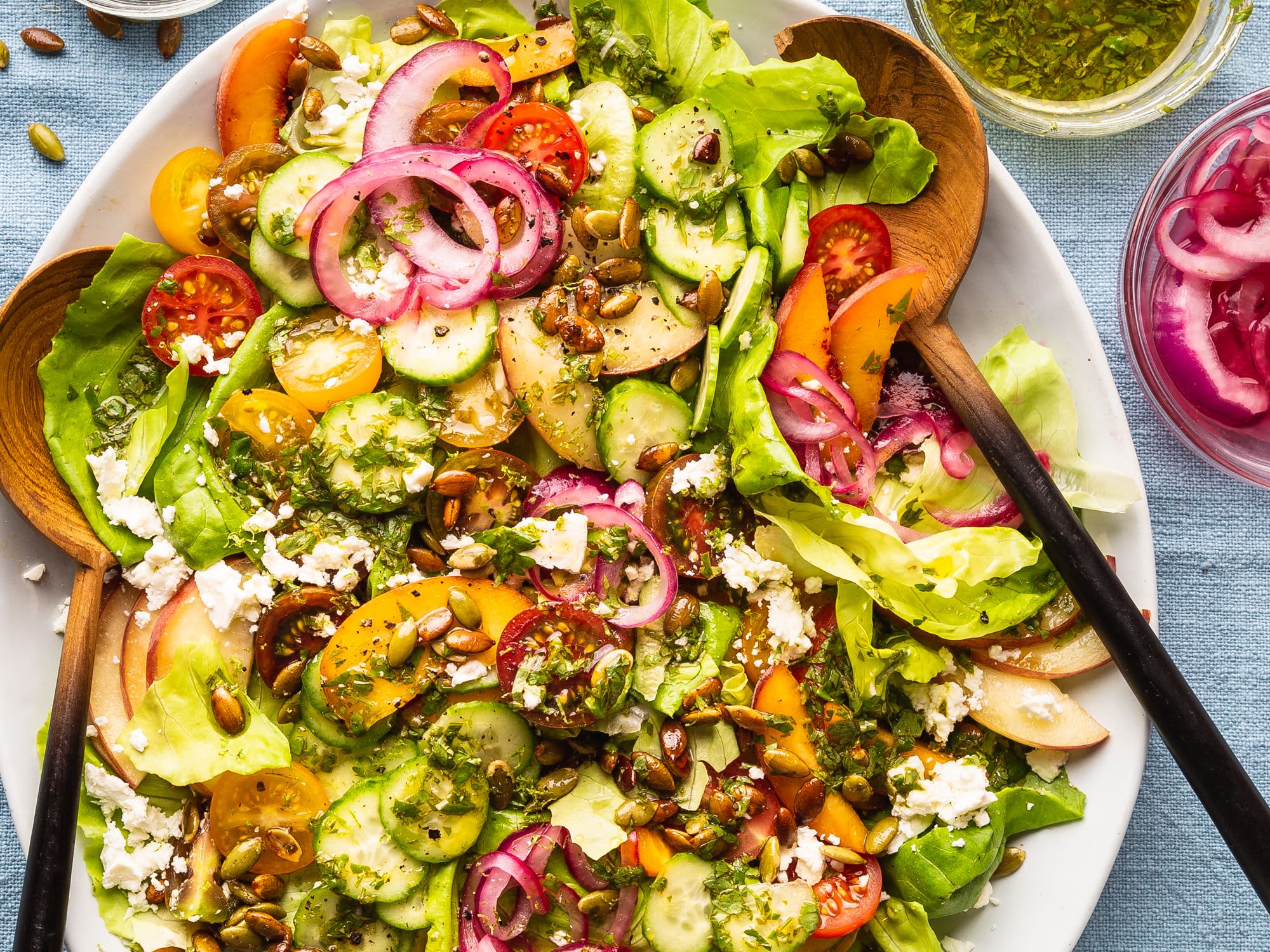 Summer salad with peaches, cherry tomatoes, cucumbers, feta, and herbs