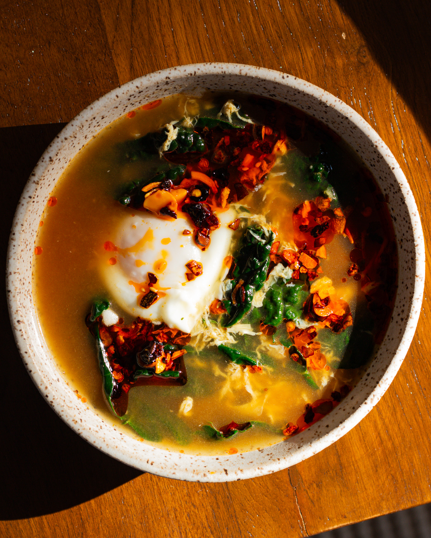 Wilted greens egg drop soup with rice and chili crisp